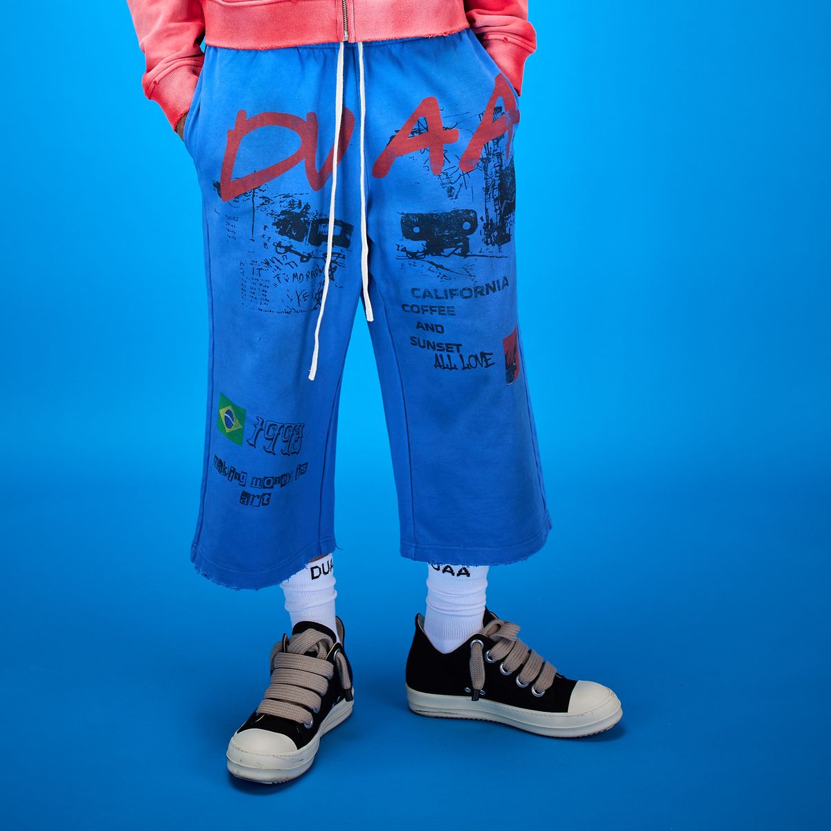 DUAA Capri Sweatpants - modelo con sweatpants capri azules con estampados gráficos