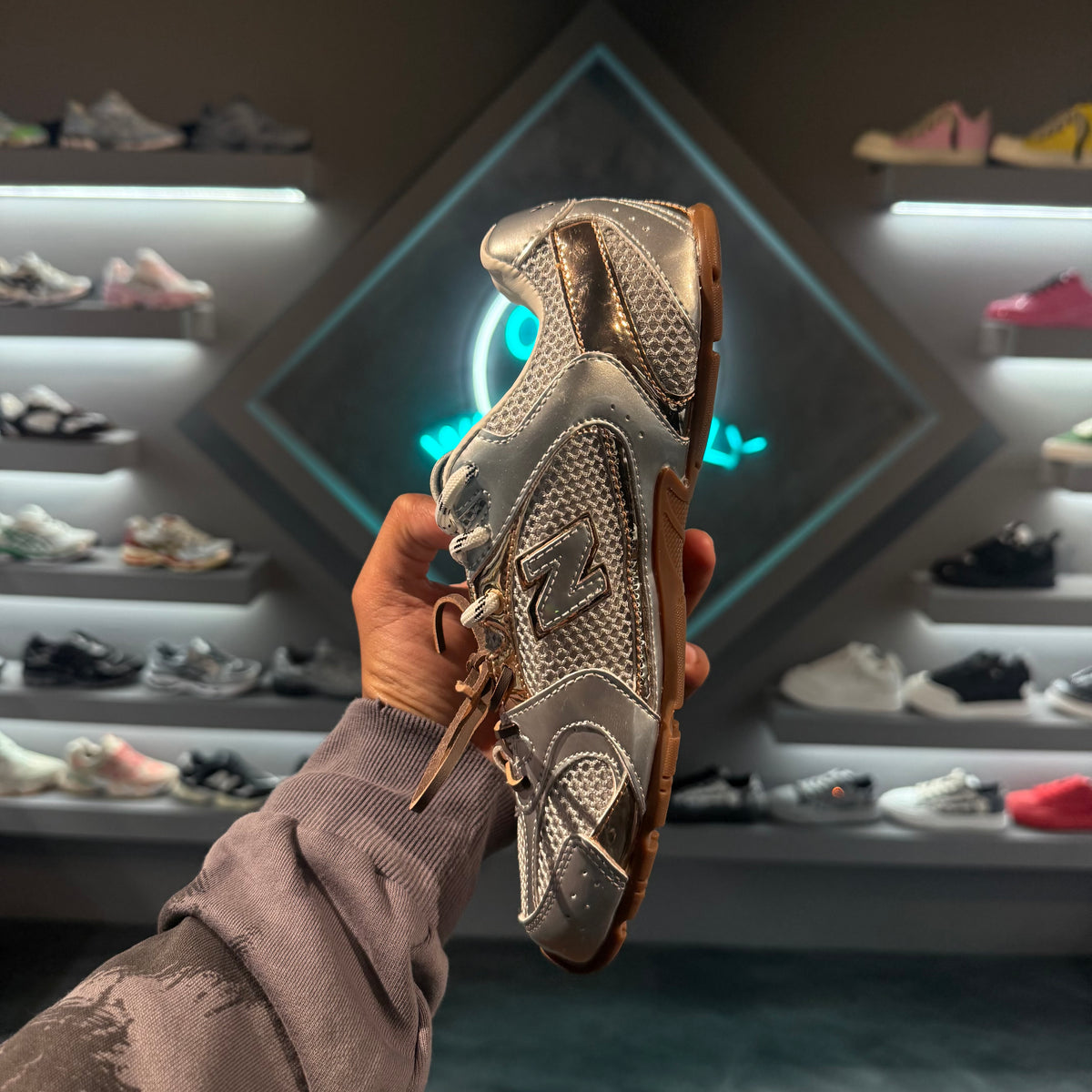 New Balance 530 Miu Miu Silver Gold - tenis plateado y dorado sostenido de pie, vista lateral