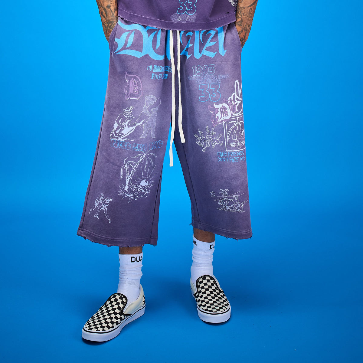 DUAA Capri Sweatpants - model wearing purple capri sweatpants with graphic prints